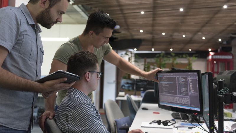 People looking at a computer monitor